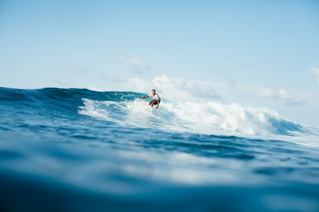 handsome athletic man surfing on ocean wave